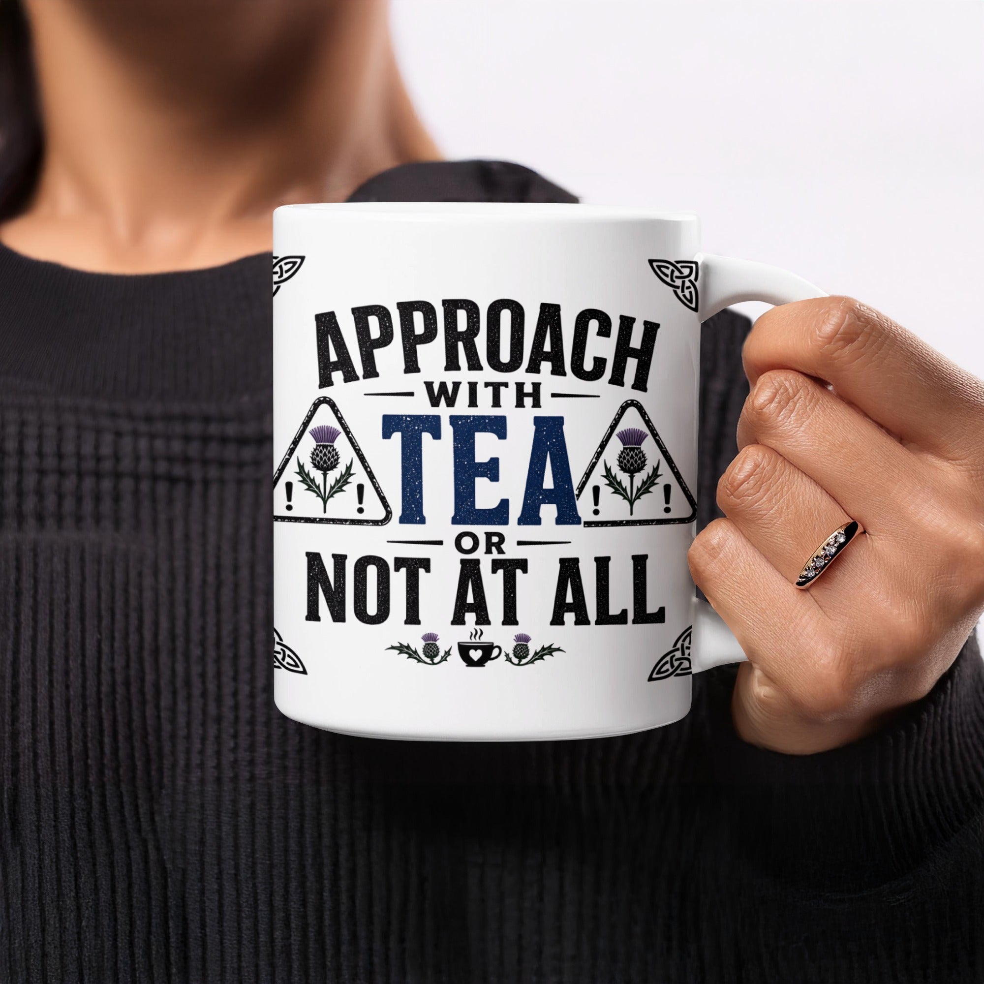 Mug with "Approach with tea or not at all" text and thistle graphic.
