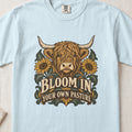 Bloom in Your Own Pasture Highland cow design on a Chambray Comfort Colors 1717 T-shirt, flat lay