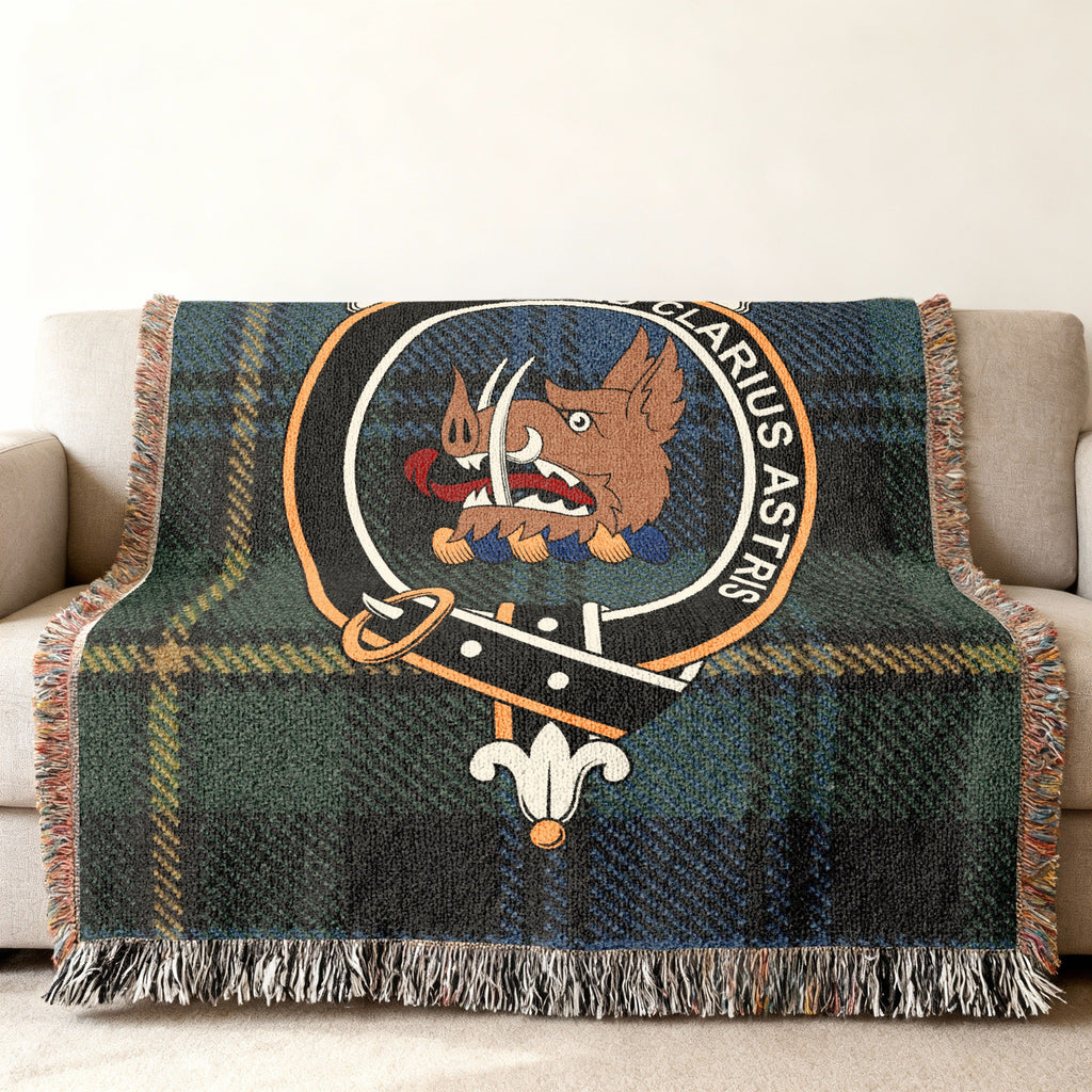 Close view of the Baillie woven blanket draped over a sofa, showing the crest and fringed edges