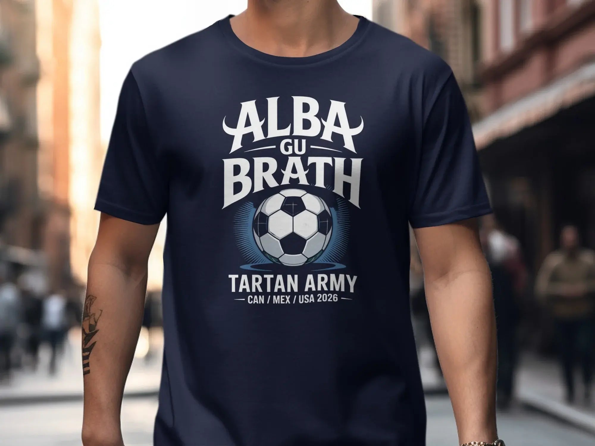 Navy t-shirt with "ALBA GU BRATH TARTAN ARMY CAN / MEX / USA 2026" and a football.