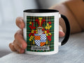 White mug with black handle featuring the Chichester coat of arms on a tartan background.
