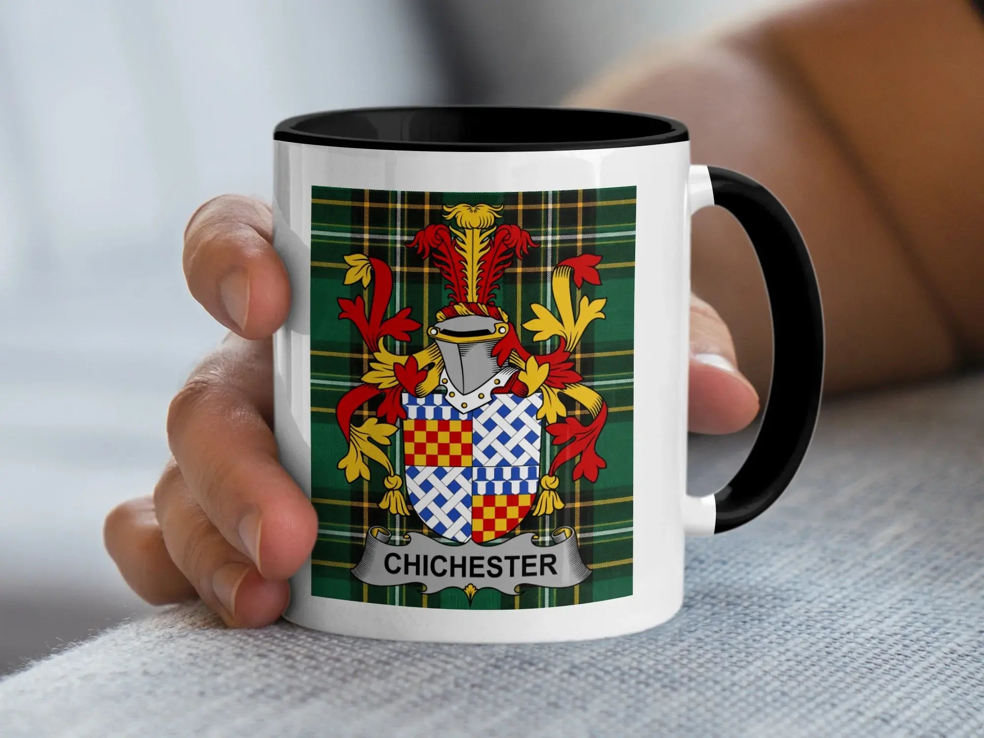 White mug with black handle featuring the Chichester coat of arms on a tartan background.