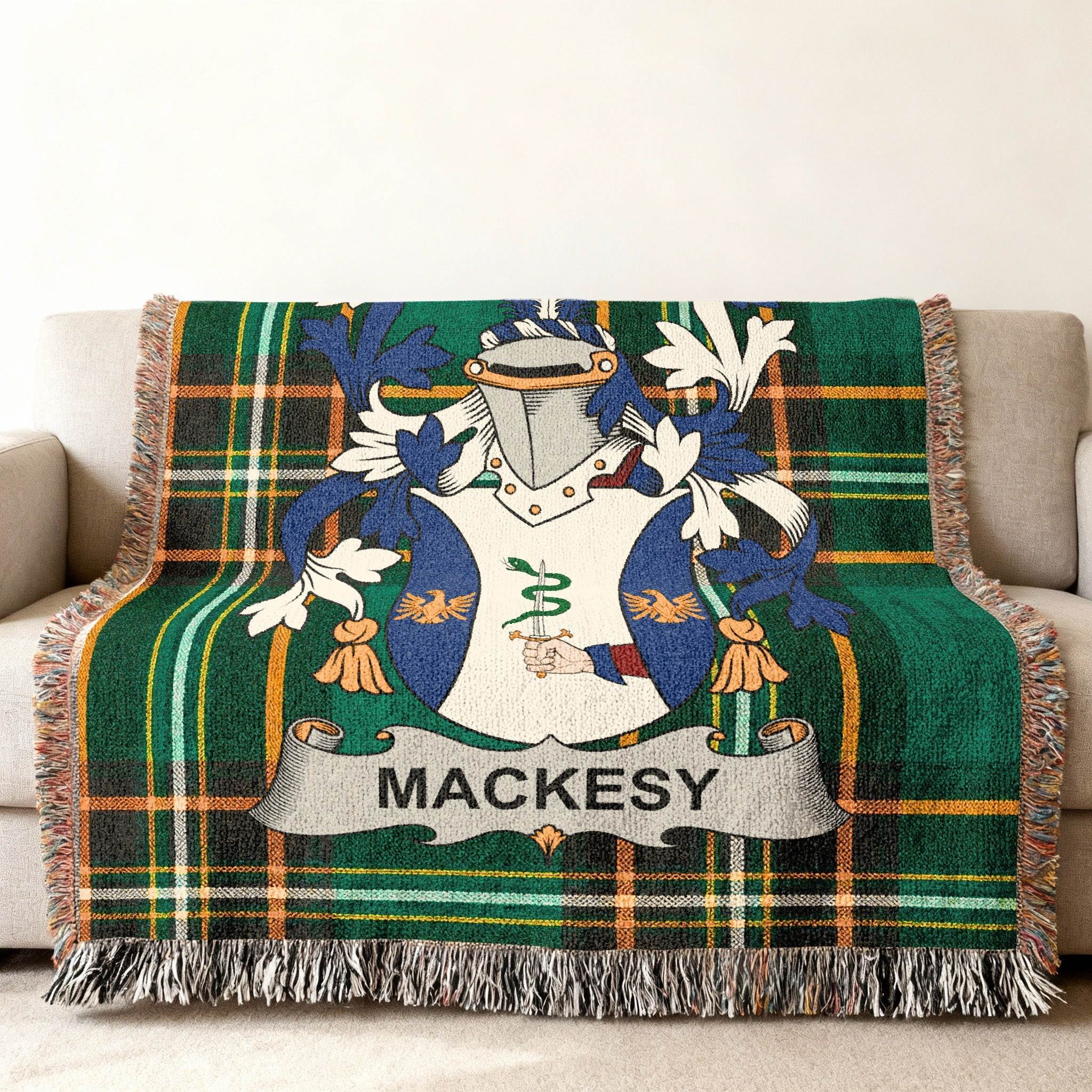 Green tartan throw blanket featuring a coat of arms with the name MACKESY.