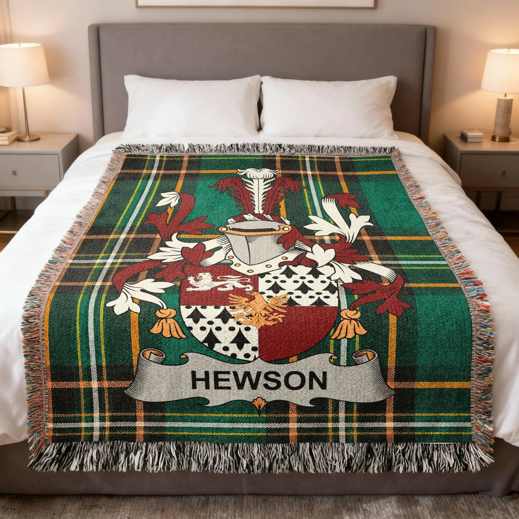 Green plaid blanket with Hewson family crest on a bed.