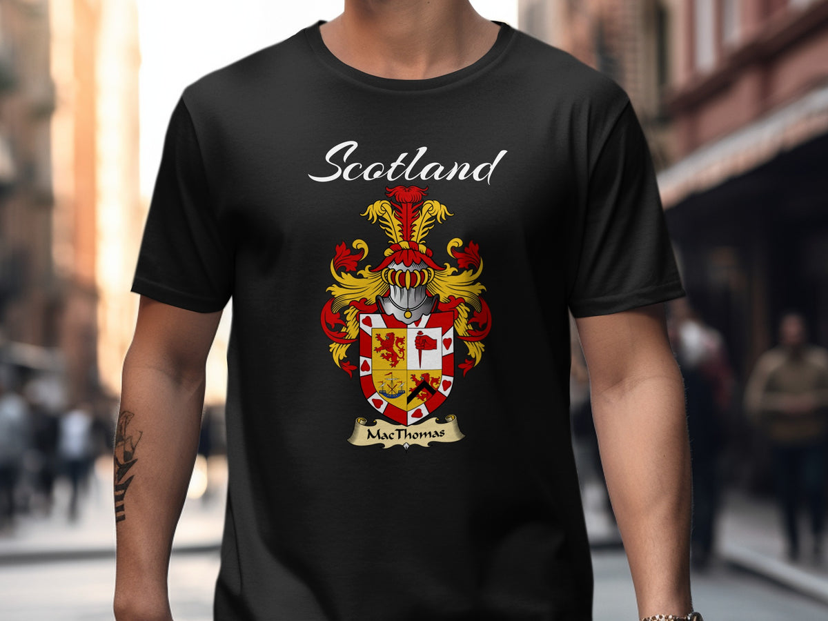 Model wearing a black MacThomas T-shirt featuring a quartered red-and-gold shield with a decorative border