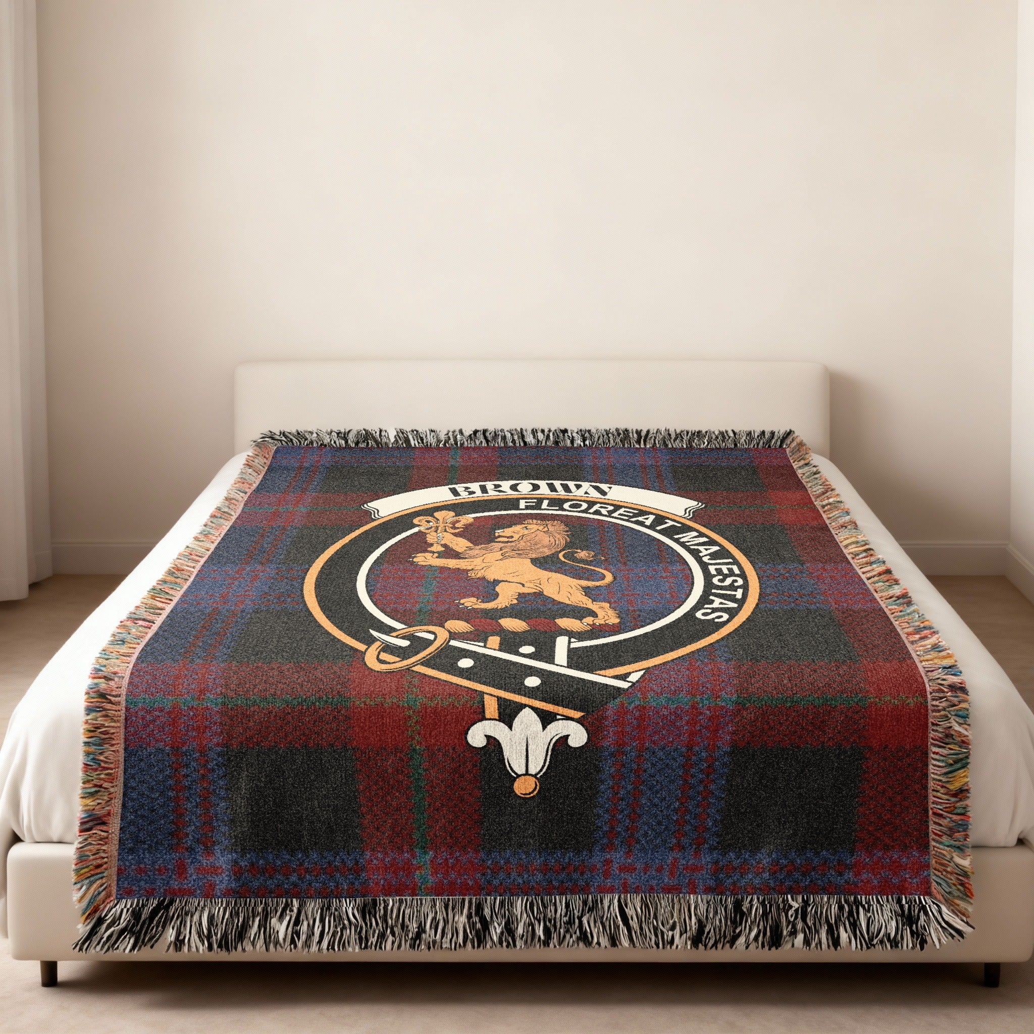 Brown family crest with lion and motto woven into tartan blanket