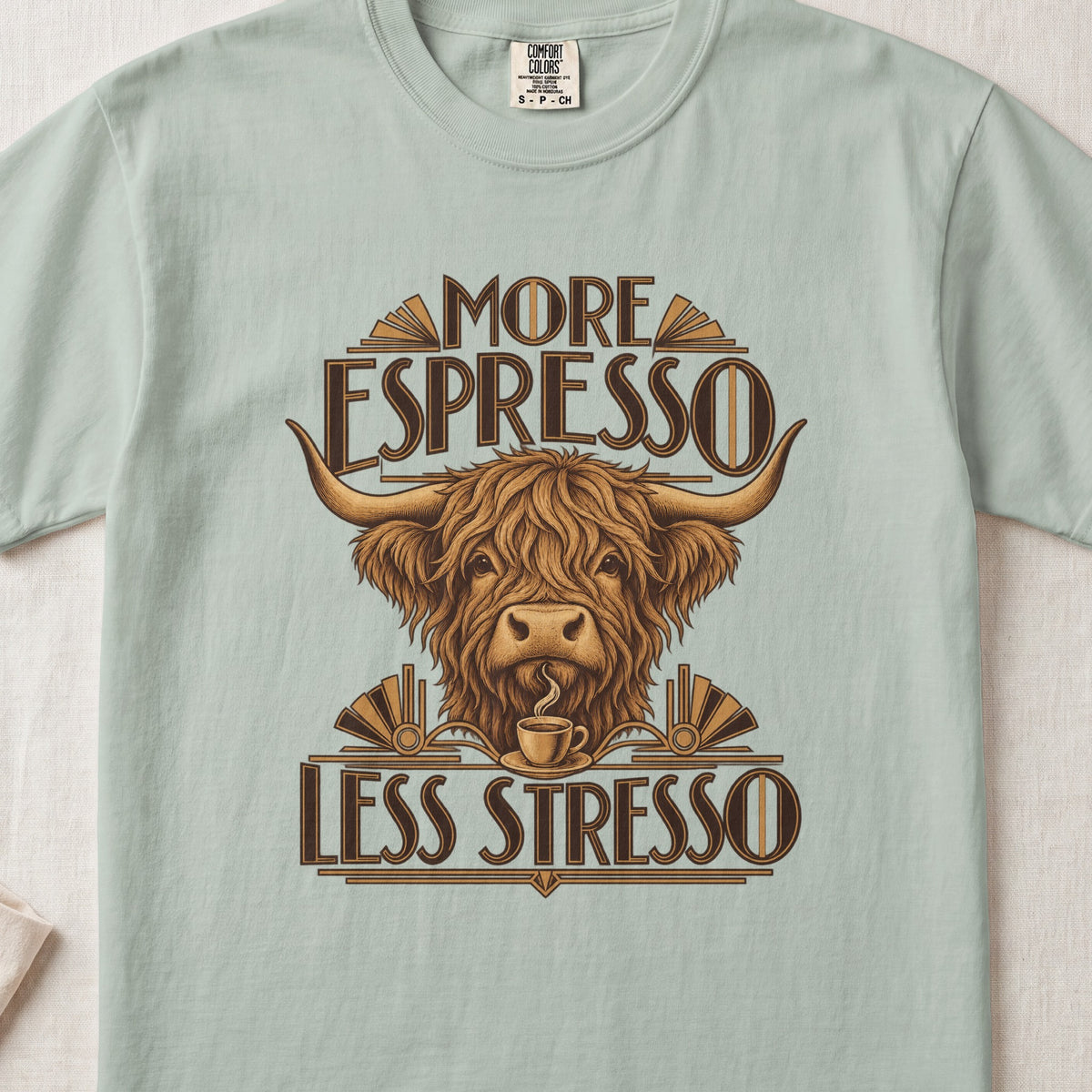 More Espresso, Less Stresso Highland cow design on a Bay Comfort Colors 1717 T-shirt, flat lay