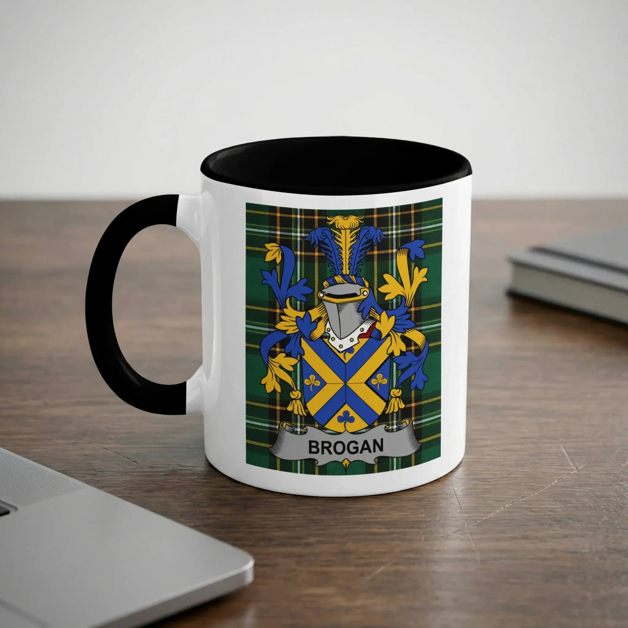 White mug with black handle featuring the Brogan family crest on a plaid background.