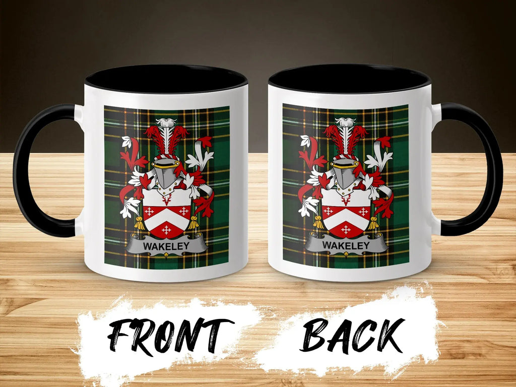 Two white mugs with black rims and handles, displaying a family crest on plaid background.