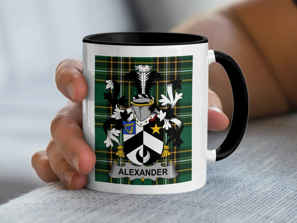 White mug with black rim featuring a plaid pattern and the Alexander family crest.
