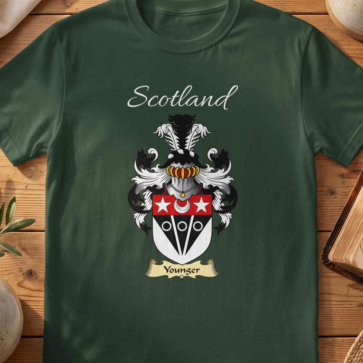 Forest Green Younger Scottish T-shirt laid flat with coat of arms artwork and “Scotland” text.