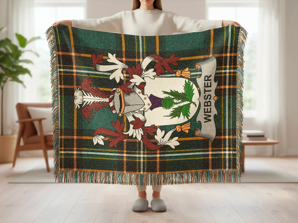 Tartan blanket with Webster coat of arms and fringe, held by person.