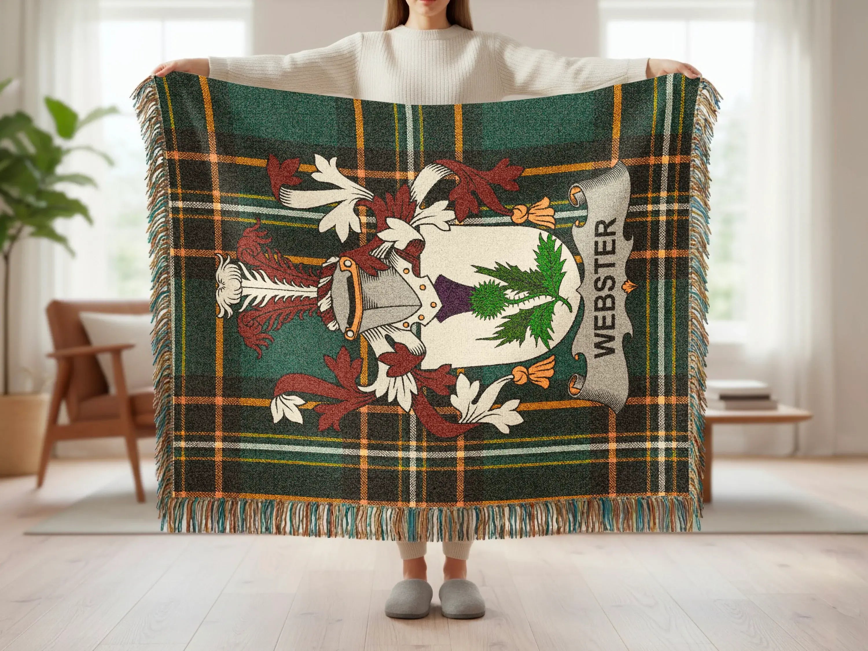 Tartan blanket with Webster coat of arms and fringe, held by person.