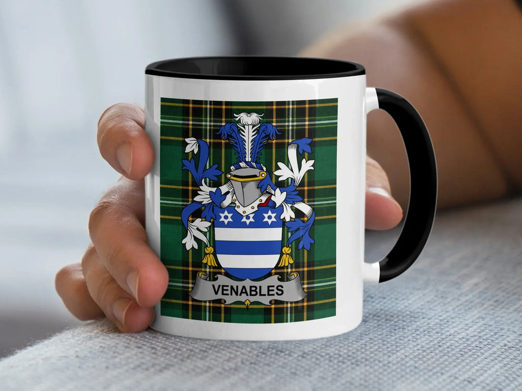 White mug with black rim featuring the Venables family crest on a plaid background.