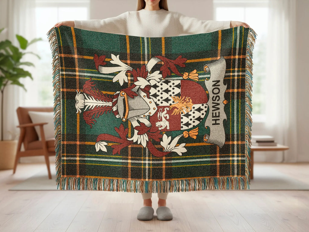 Hewson tartan throw blanket with crest displayed by a person.
