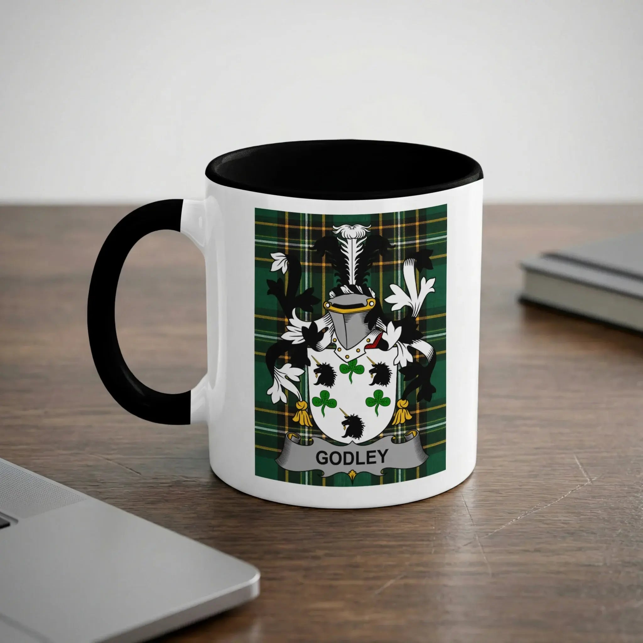 White mug with black rim and handle featuring a green, black, and white crest with the name "GODLEY".