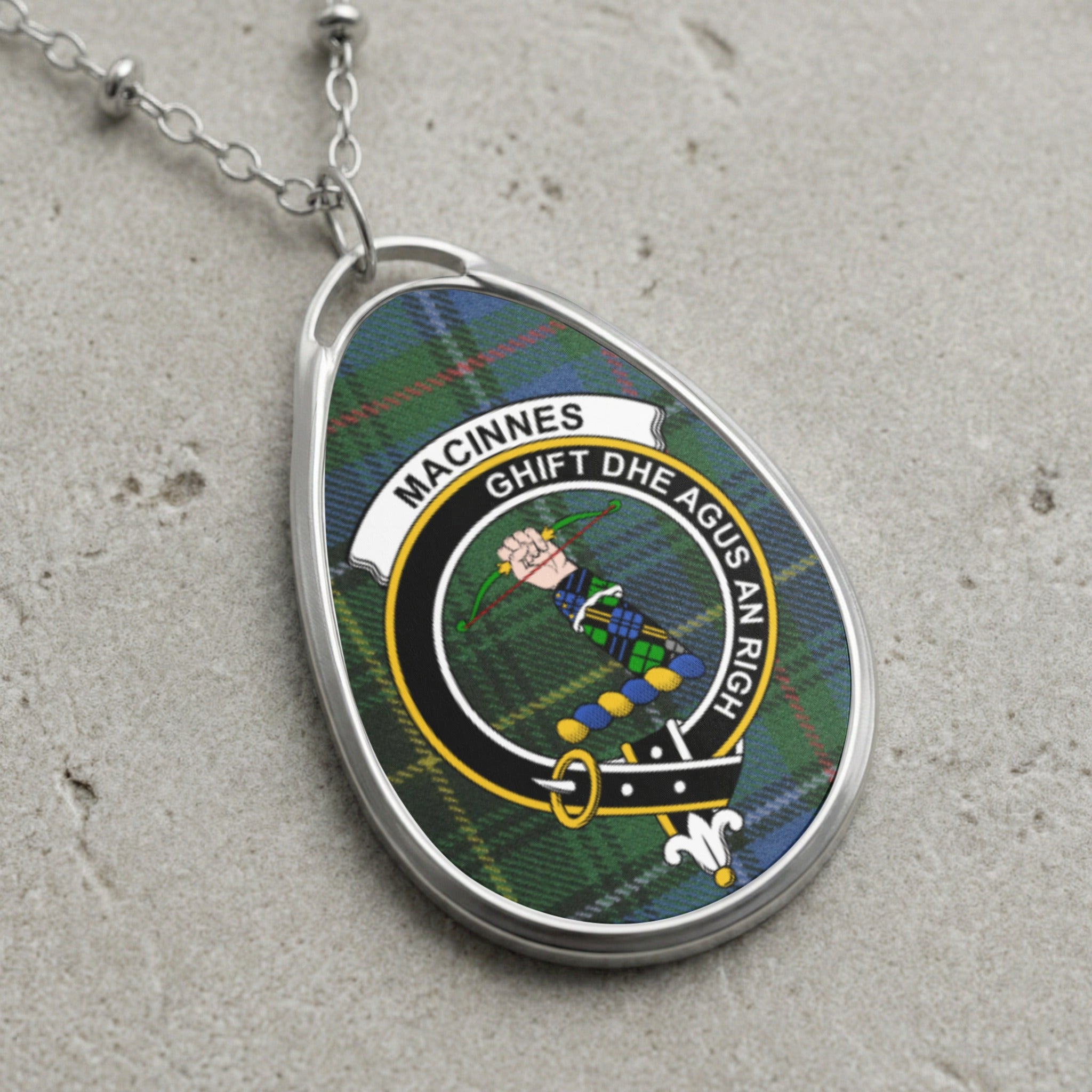 Oval pendant necklace featuring MacInnes tartan and crest with motto.