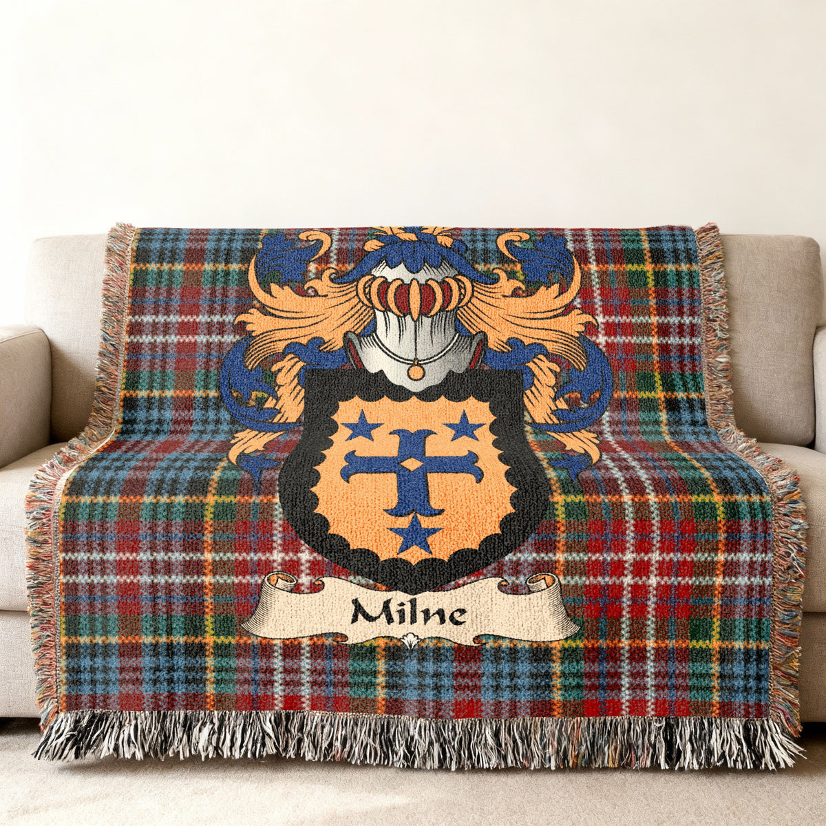 Milne family crest emblem on a Caledonia tartan woven blanket