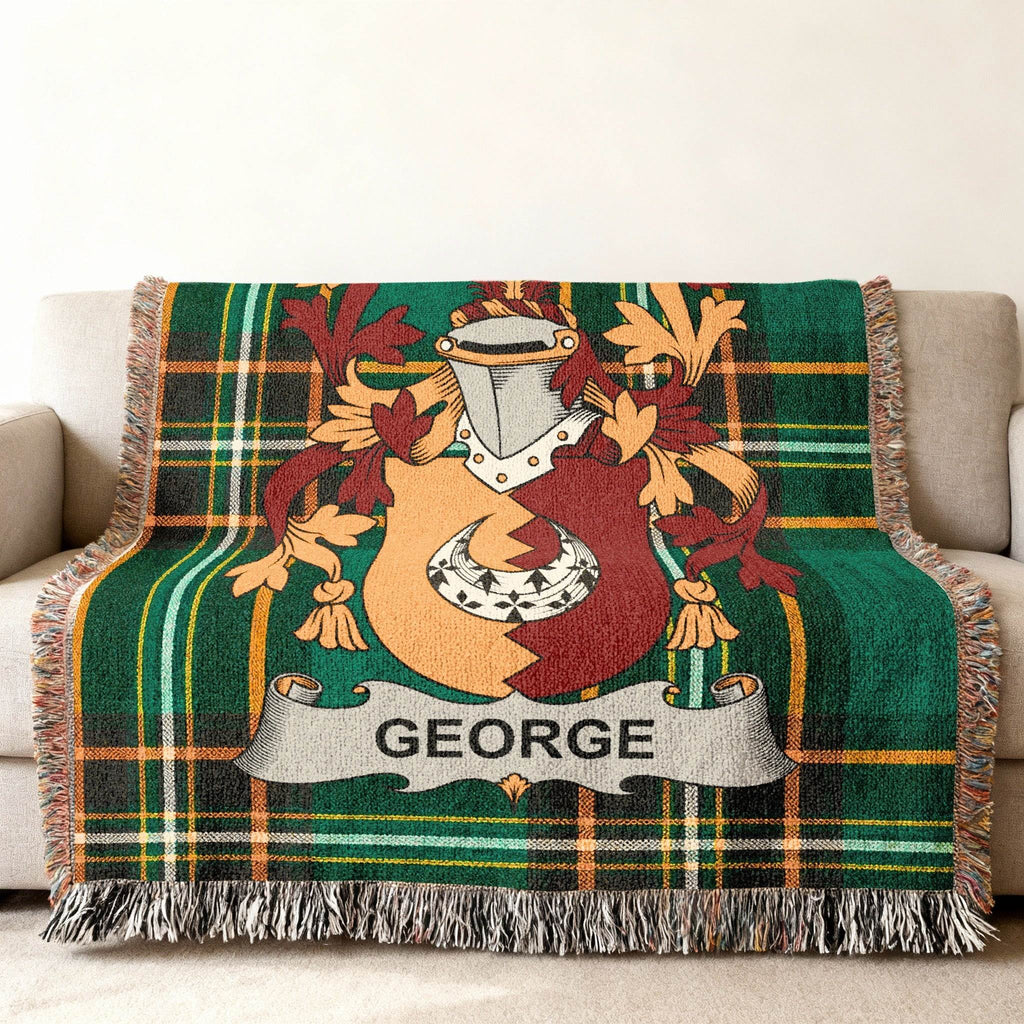 Tartan blanket with George family crest on a sofa.