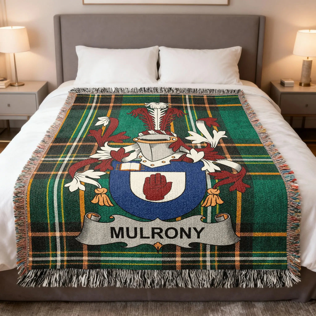 Tartan blanket with Mulroney clan crest on a bed.