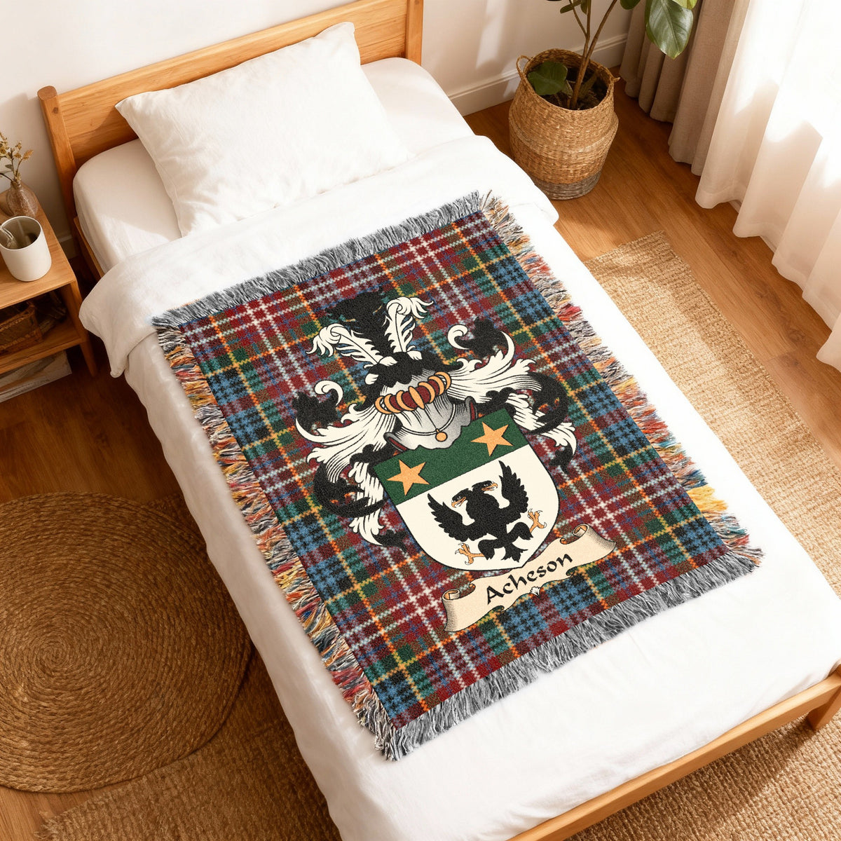 Acheson Scottish family shield woven blanket with Caledonia tartan background, displayed on a bed