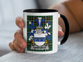 White mug with black rim featuring Harforth coat of arms on plaid background.