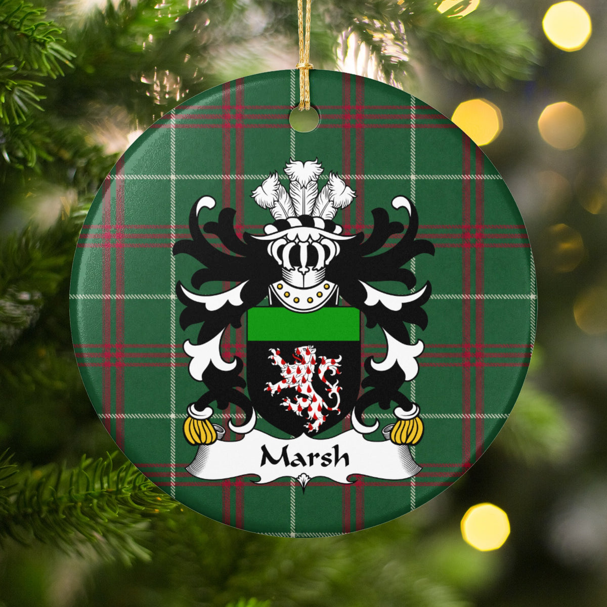 Marsh ornament hanging among Christmas tree branches and warm lights, with a red-and-white patterned lion on a black shield with a green top band on Welsh National Tartan.