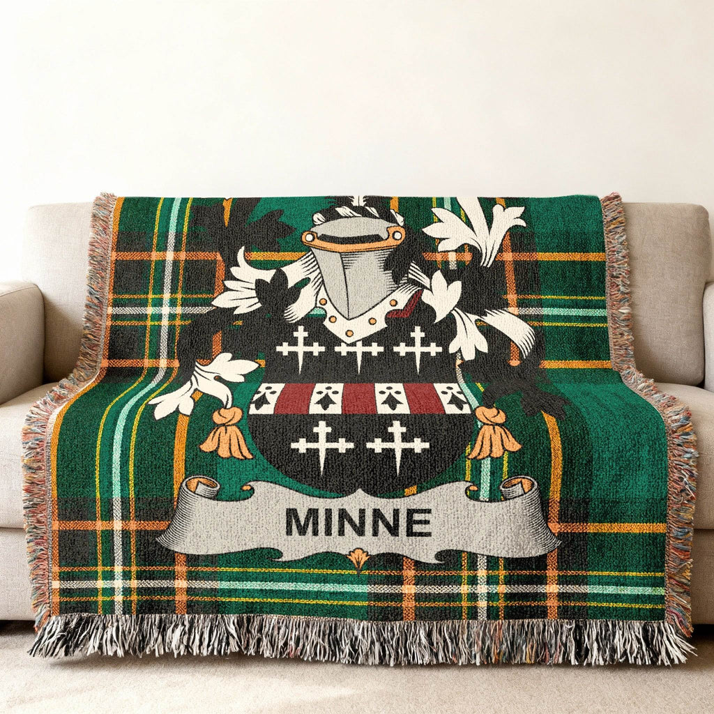 Woven blanket with a green tartan pattern and the MINNE family crest.