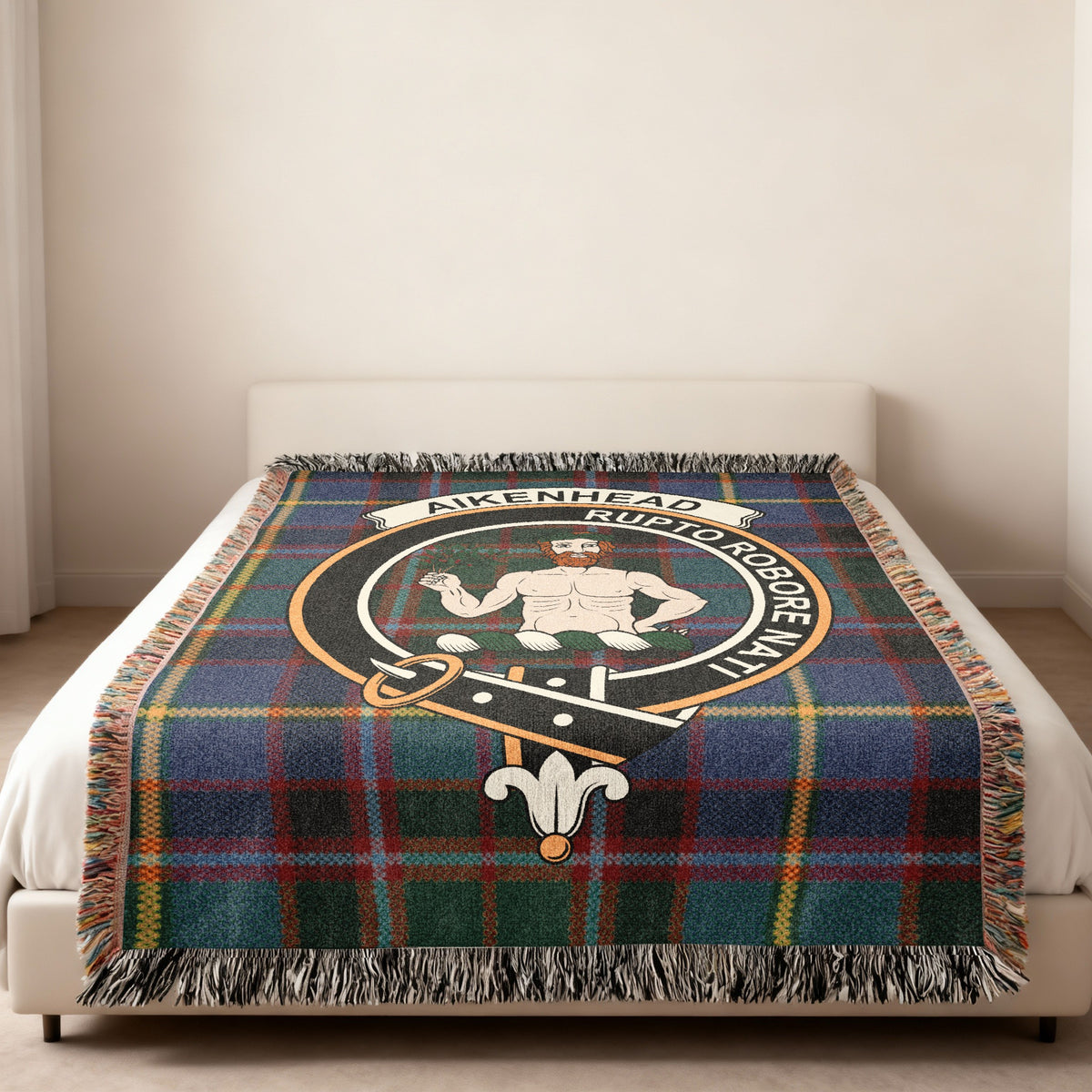 Aikenhead Scottish woven blanket spread across a bed, showing the full crest design and tartan background