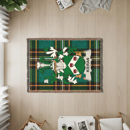 Kieran tartan woven blanket with family crest on wooden floor.
