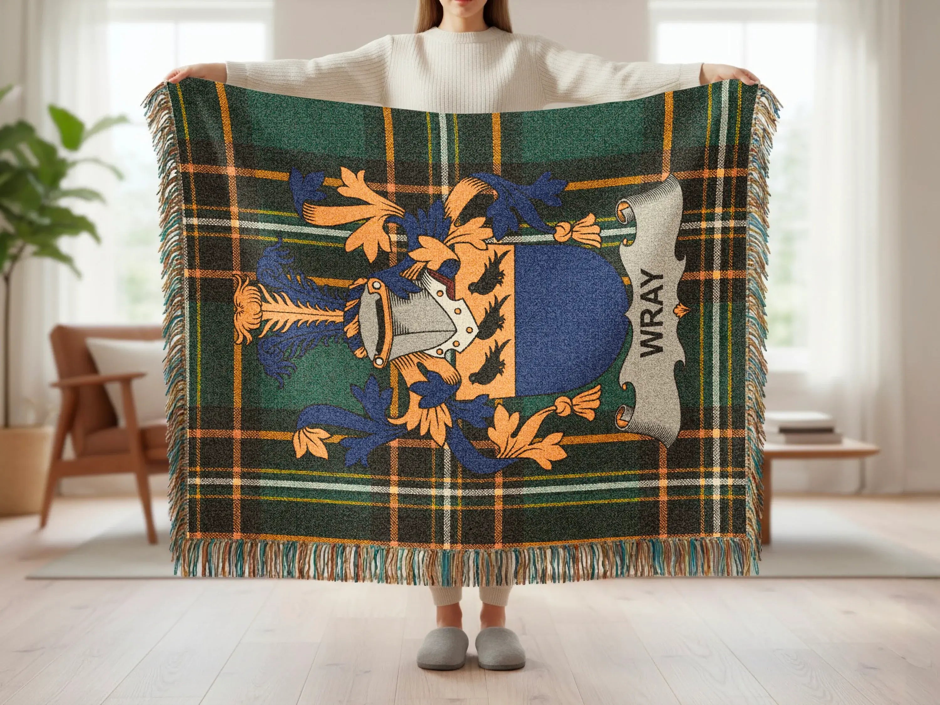 Tartan blanket with Wray crest, held up by a person.