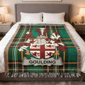 Plaid throw blanket with Goulding family crest, displayed on a bed.