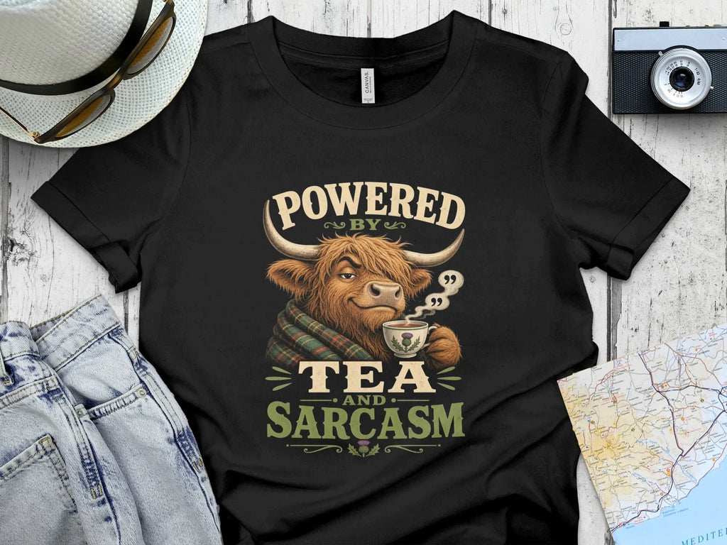 Highland cow wearing scarf, drinking tea, with text "POWERED BY TEA AND SARCASM".
