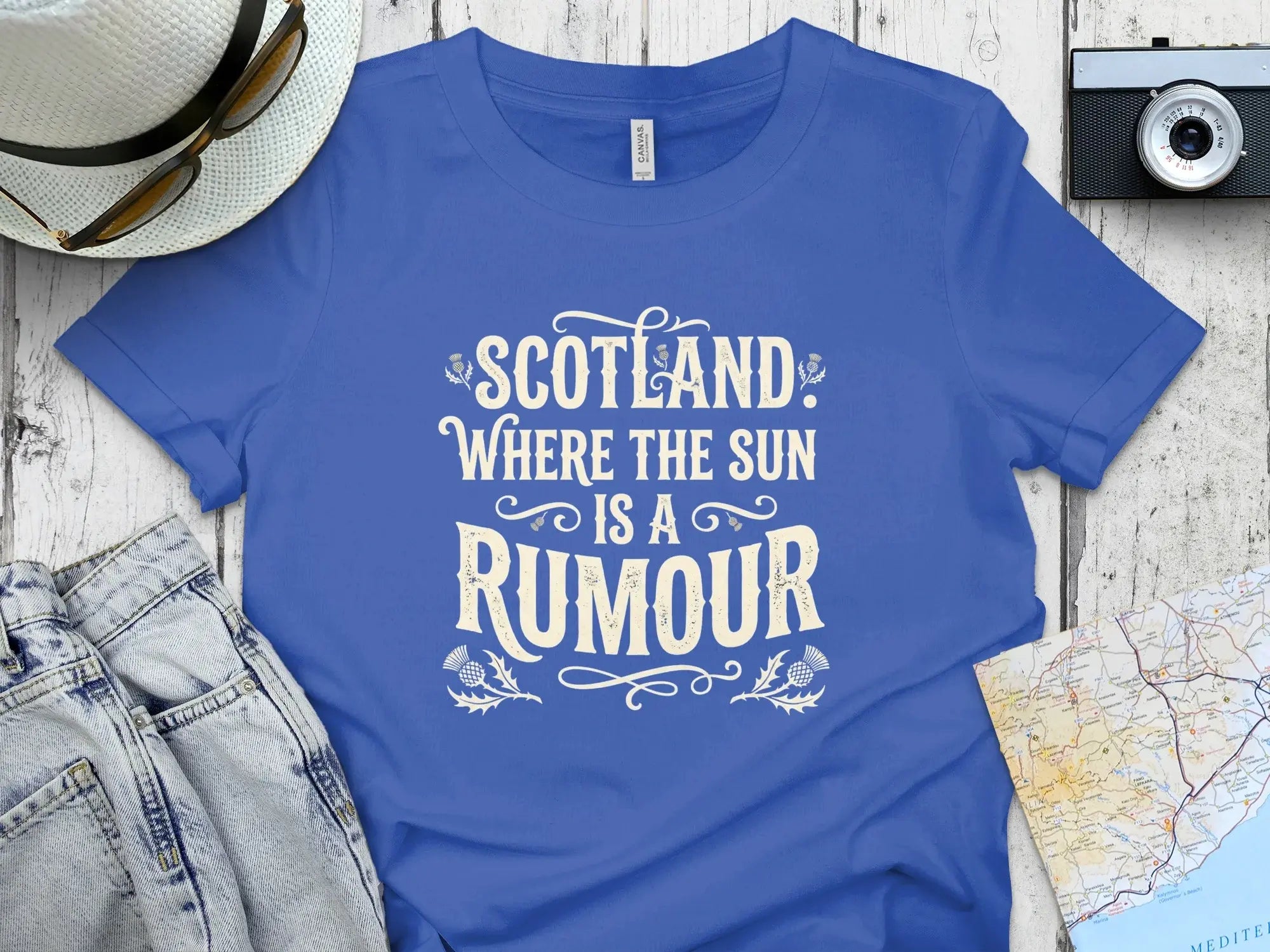 Blue t-shirt with "Scotland: Where the Sun is a Rumour" text.