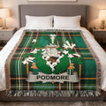 Green plaid blanket with Podmore family crest on a bed.