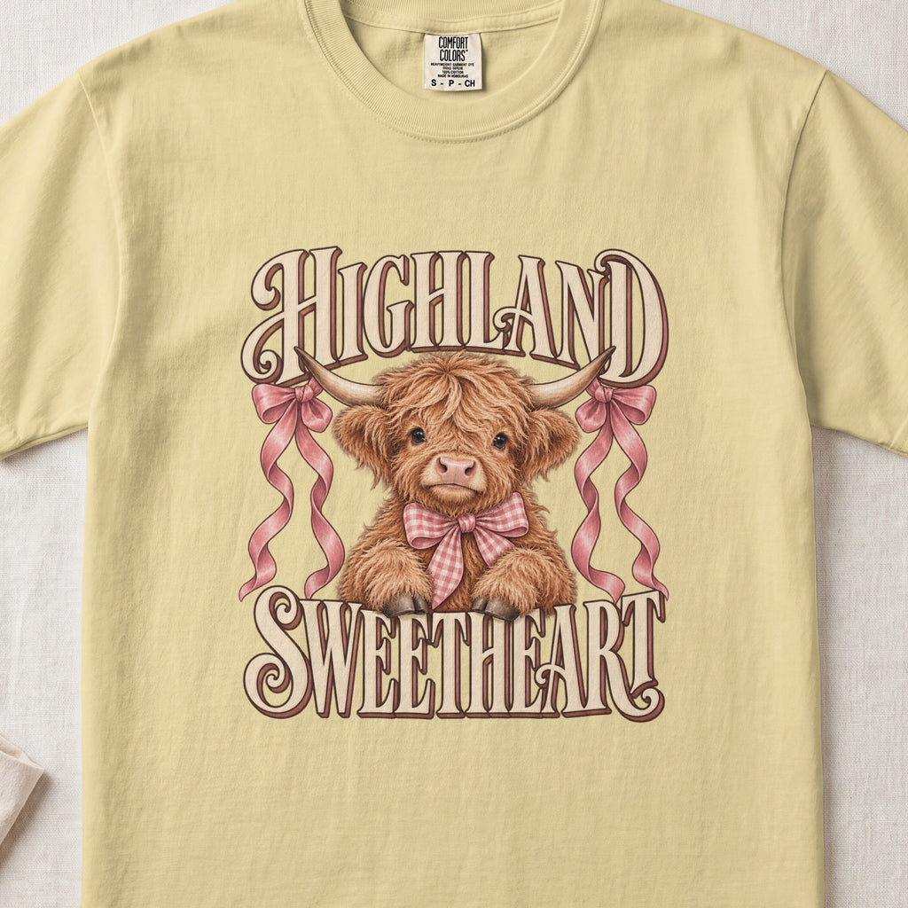 Highland Sweetheart Highland cow design on a Butter Comfort Colors 1717 T-shirt, flat lay