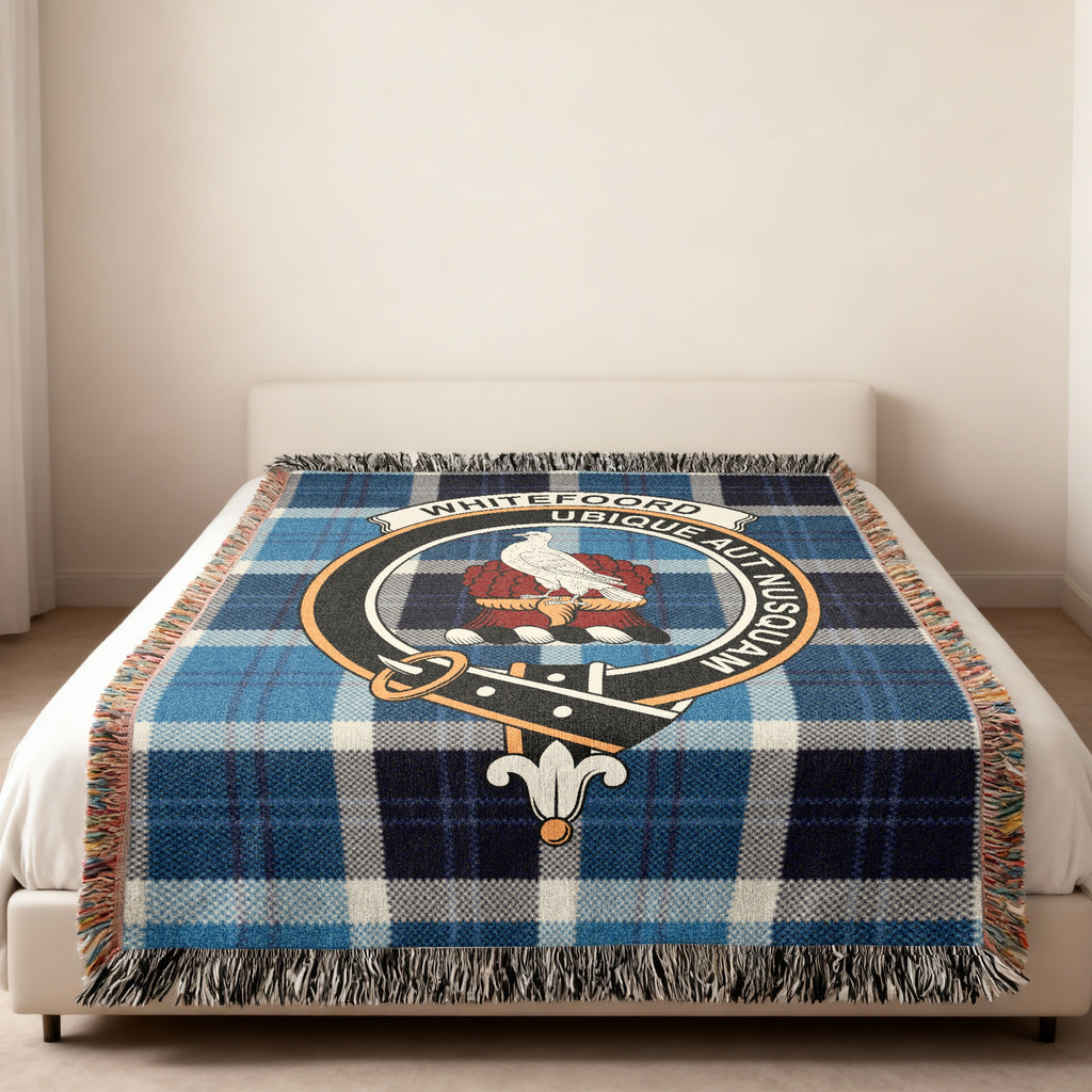 Whitefoord Scottish woven blanket spread across a bed, showing the full crest design and tartan background