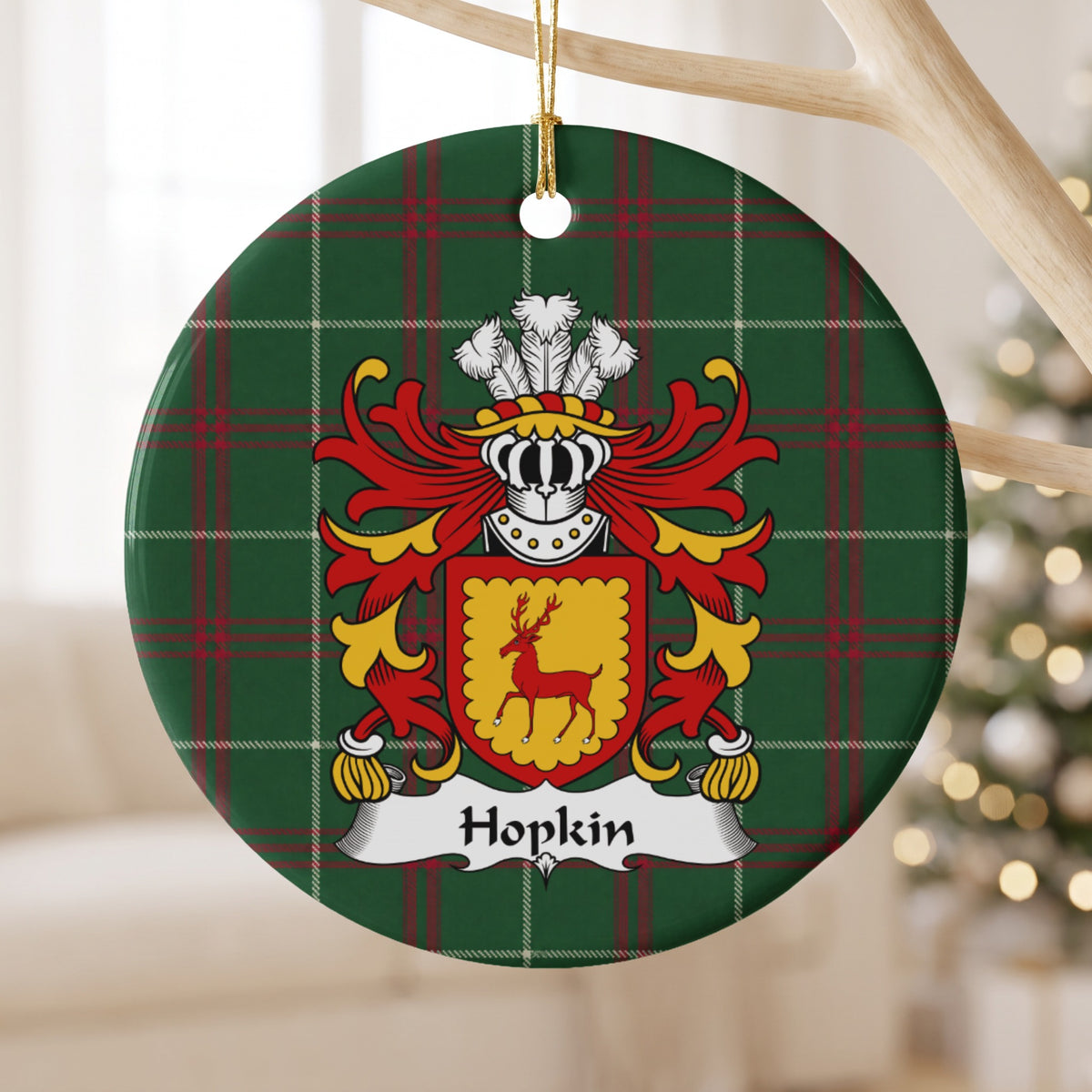 Hopkin ornament hanging from a pale wooden branch; a red stag on a gold shield with a scalloped red border on Welsh national tartan.
