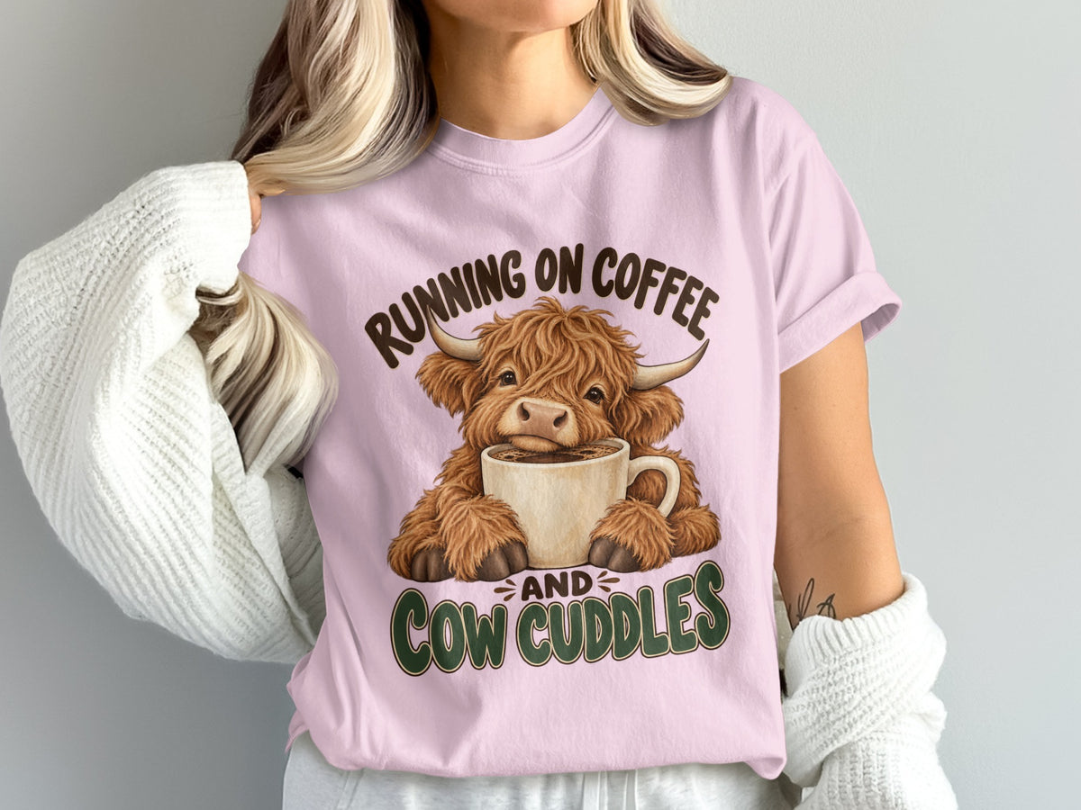 Model wearing the Running on Coffee & Cow Cuddles Highland cow Comfort Colors T-shirt in Blossom