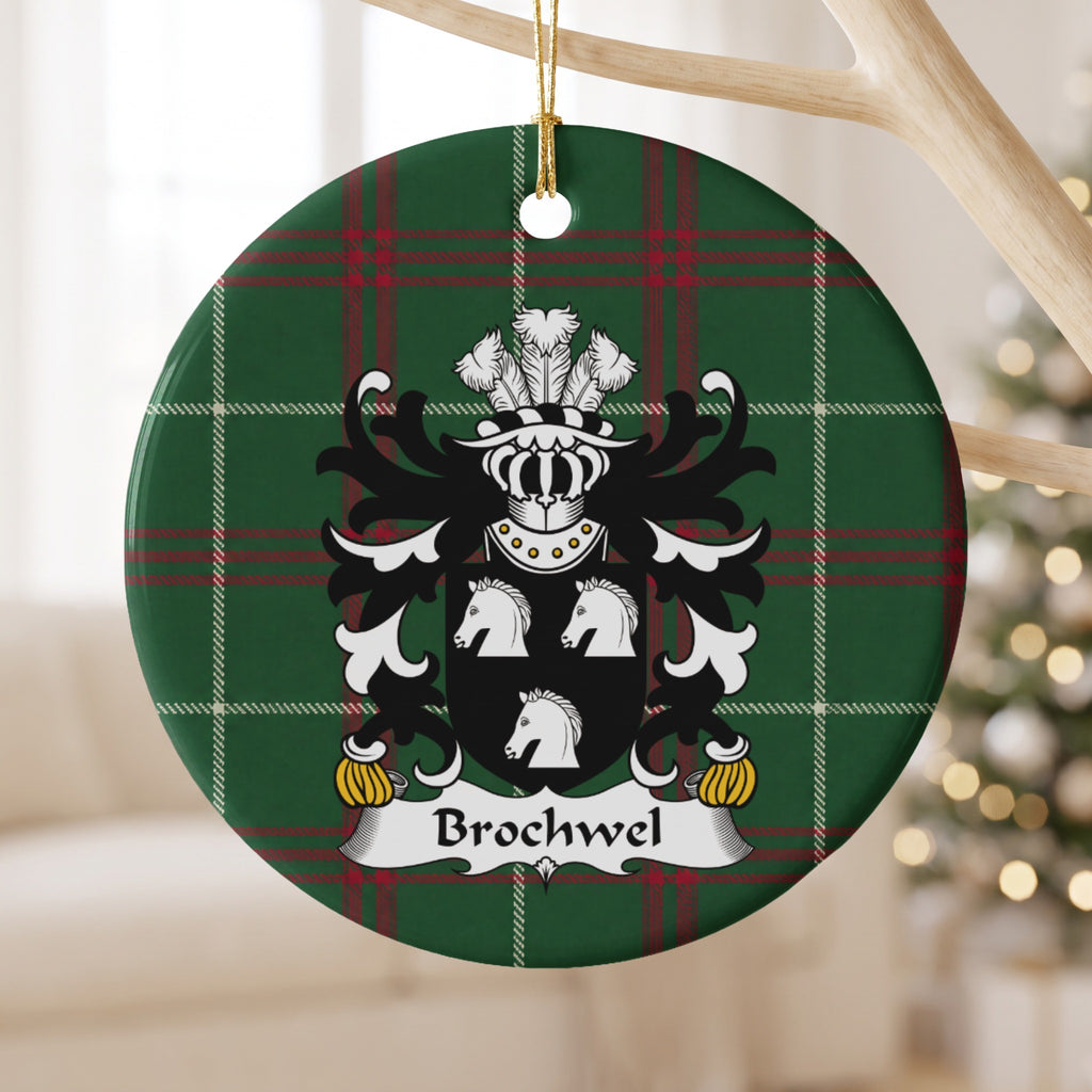 Brochwel Style 1 ornament hanging from a pale wooden branch; three white horse heads on a black shield on Welsh national tartan.