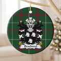 Brochwel Style 1 ornament hanging from a pale wooden branch; three white horse heads on a black shield on Welsh national tartan.