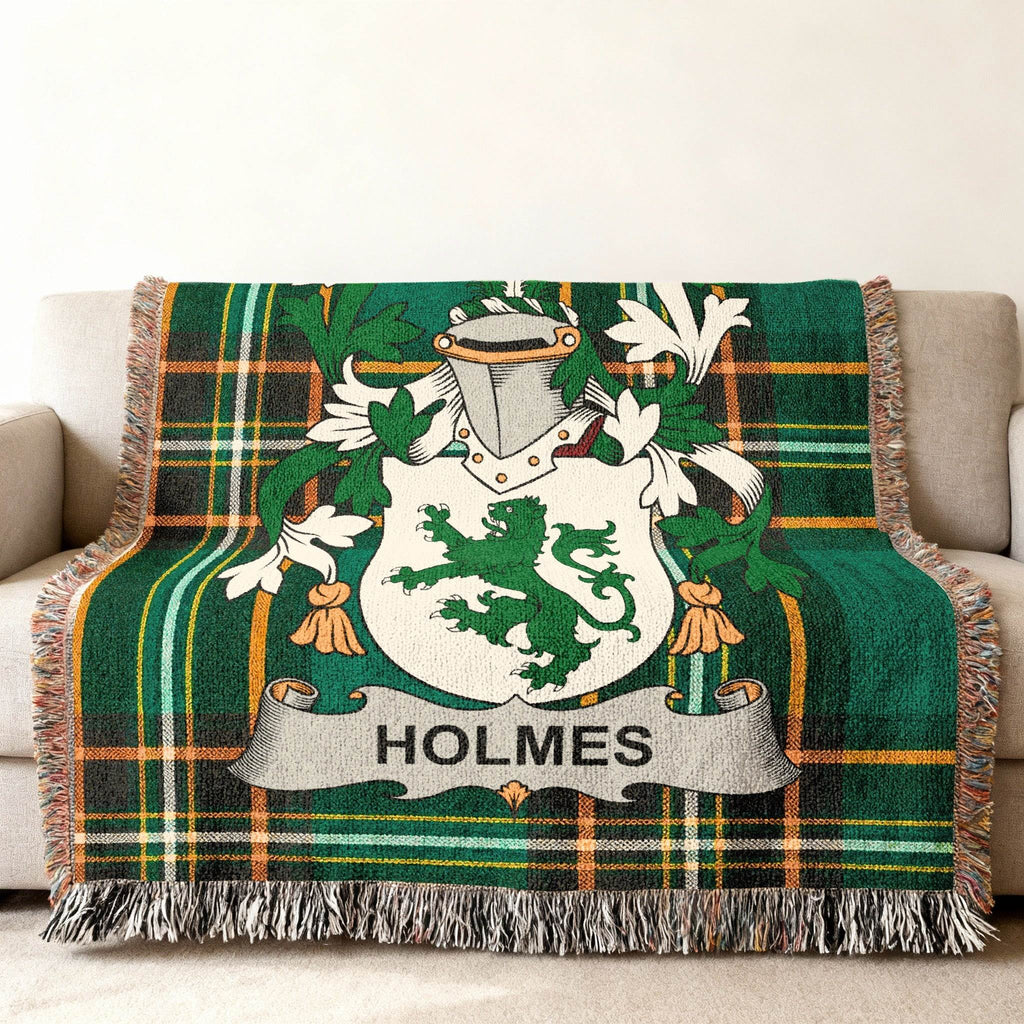Holmes family crest on a green plaid woven blanket draped over a sofa.