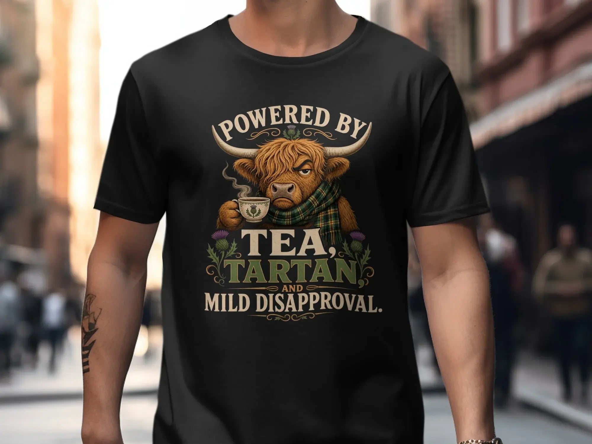 Highland cow in tartan scarf holding tea mug with text "Powered by Tea, Tartan, and Mild Disapproval."