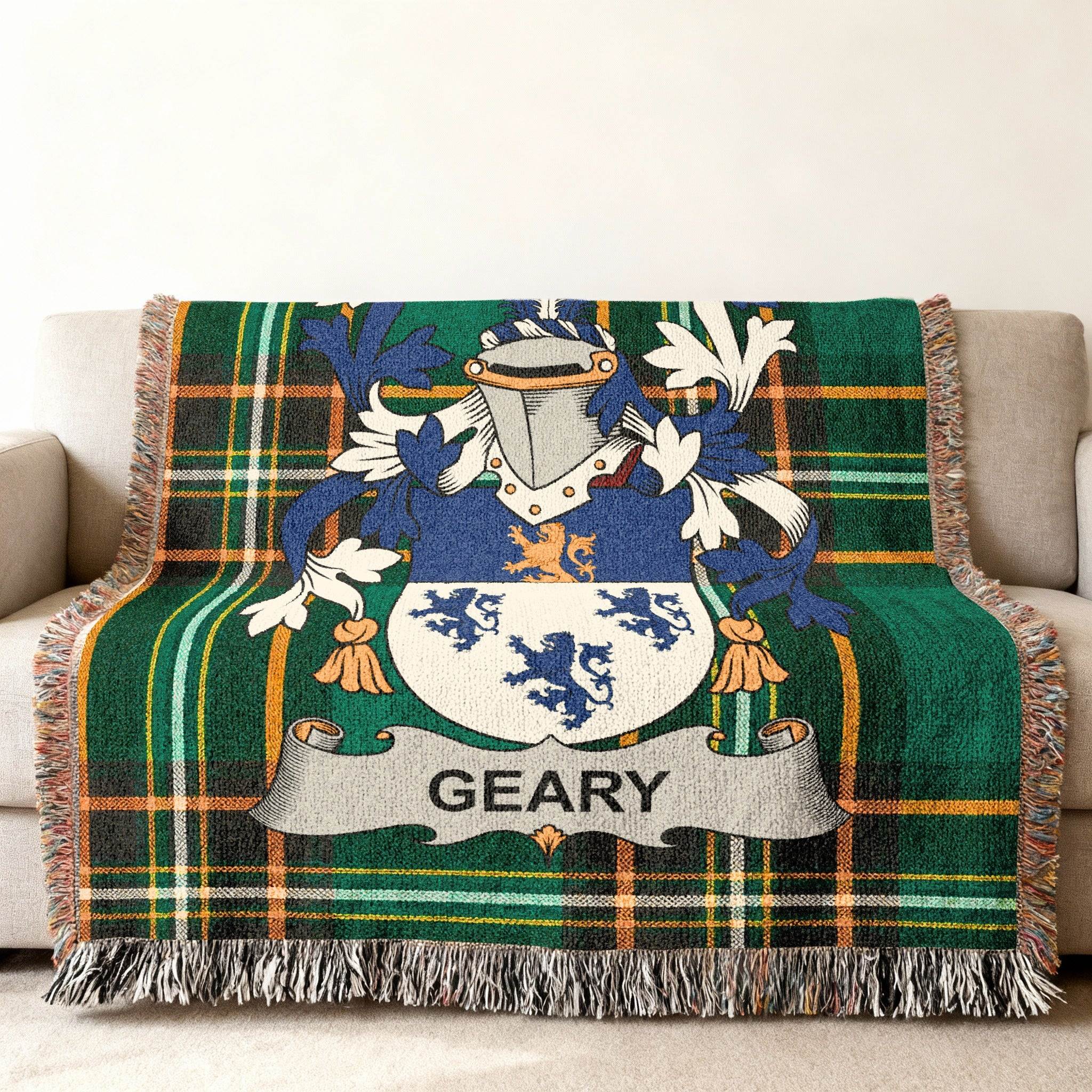 Geary tartan throw blanket with family crest on a couch.