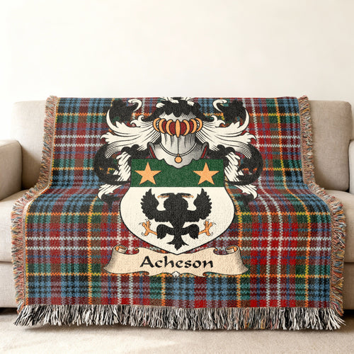 Acheson Scottish family shield woven blanket with Caledonia tartan background on a sofa