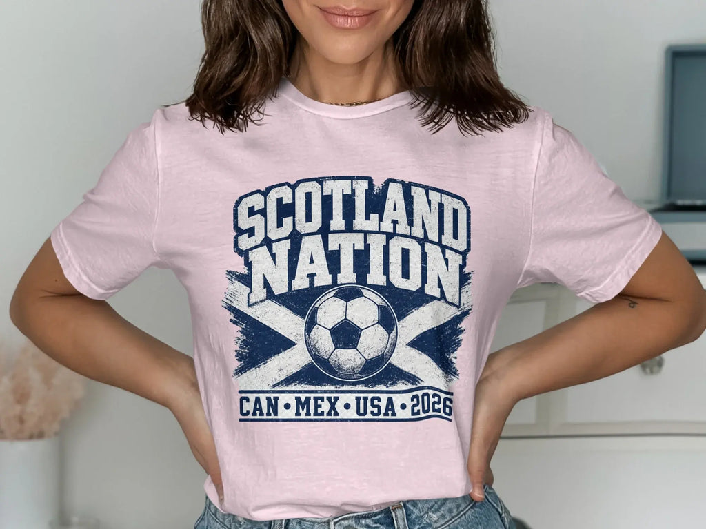 Light pink t-shirt with "SCOTLAND NATION" text, soccer ball, and "CAN MEX USA 2026".
