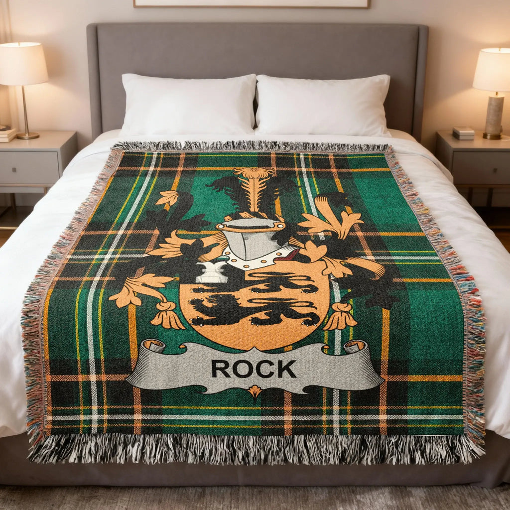 Tartan blanket with a crest bearing the name "ROCK" displayed on a bed.