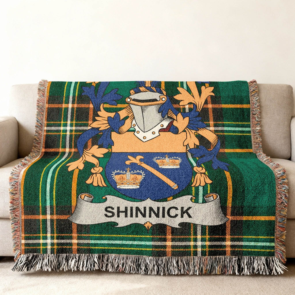 Green tartan woven blanket with the SHINNICK family crest centered on it.