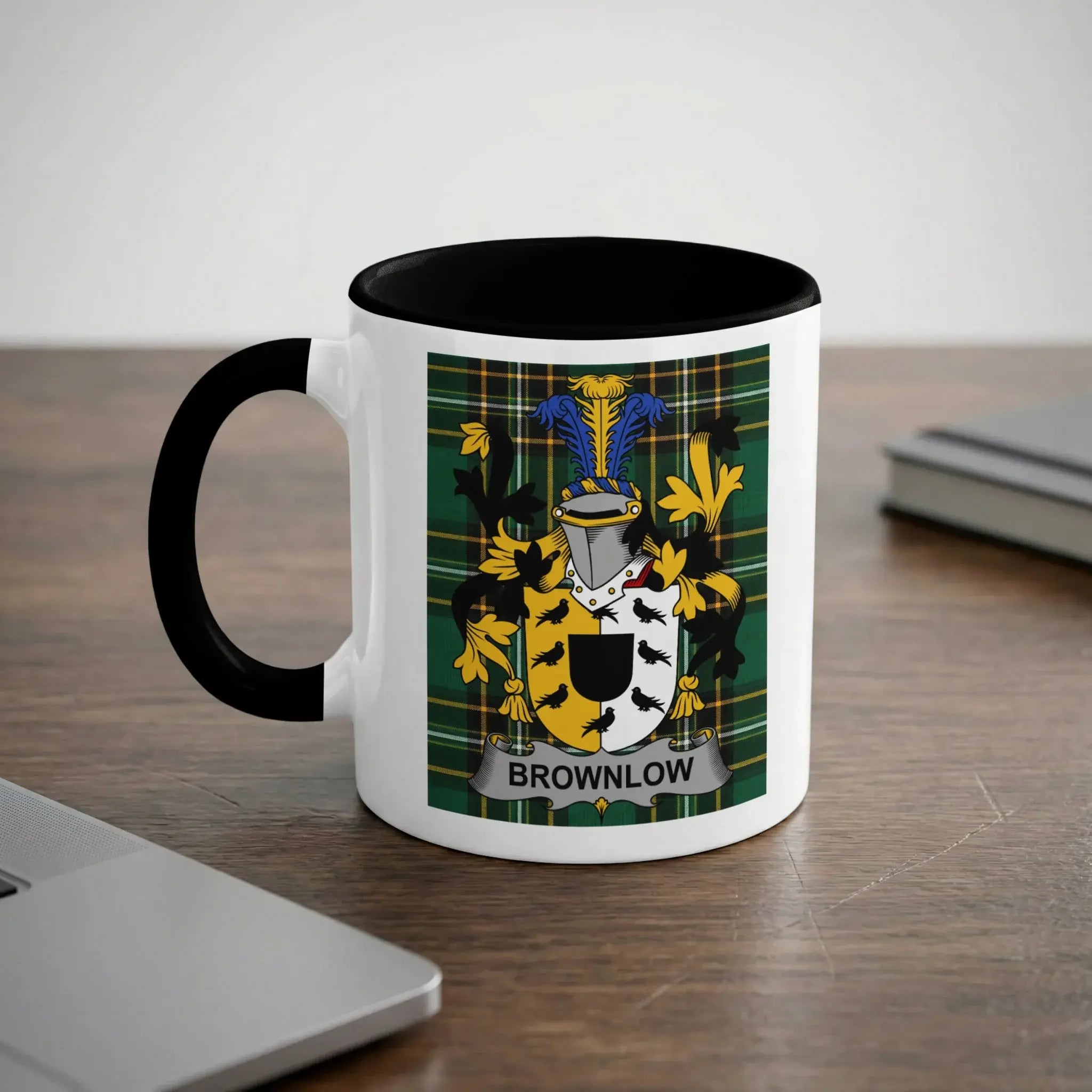White mug with black rim featuring the Brownlow family crest on a tartan background.