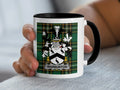 Mug with the Warburton family crest on a green tartan background.
